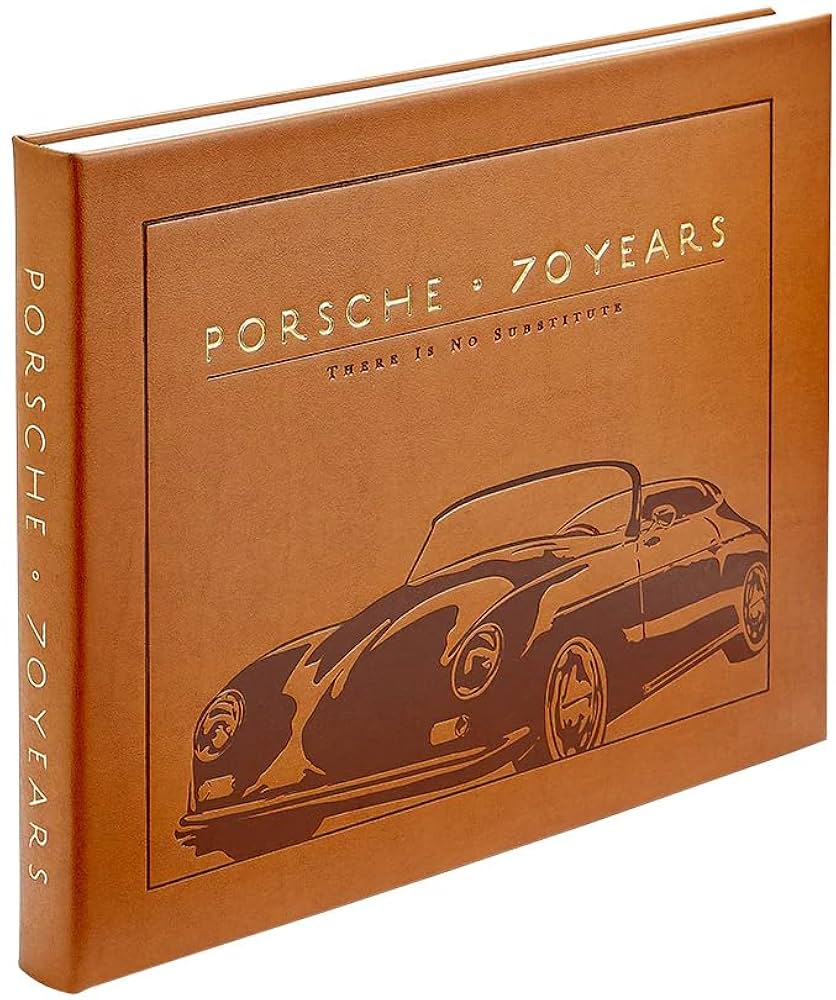 Brown leather book titled 'Porsche 70 Years' with a vintage car illustration on a white background