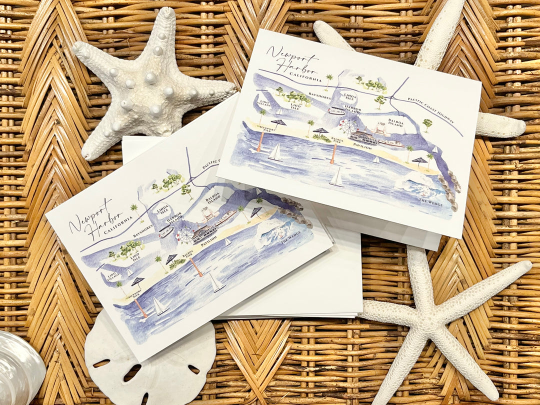 Set of postcards with a coastal design on a wicker surface with starfish and sand dollars.
