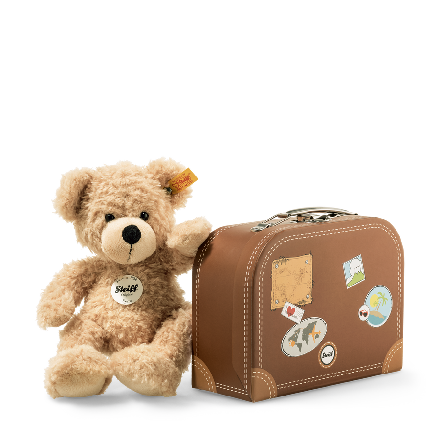 Teddy bear with a suitcase on a white background