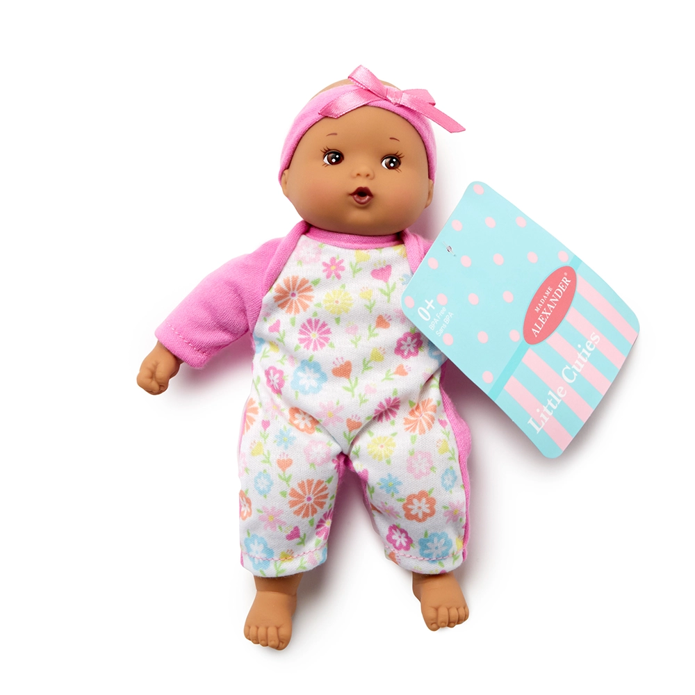 Baby doll with floral outfit and pink headband, accompanied by a matching box on a white background