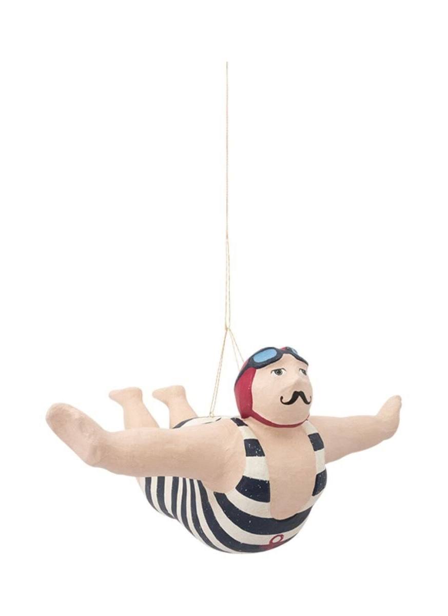 Decorative figure of a man in a swimsuit hanging from a string on a white background